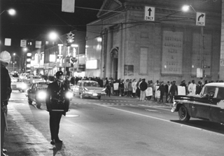 Students from North Carolina College march double-file to the site of the protest, watched over by police officers. Photo by Bill Boyarsky